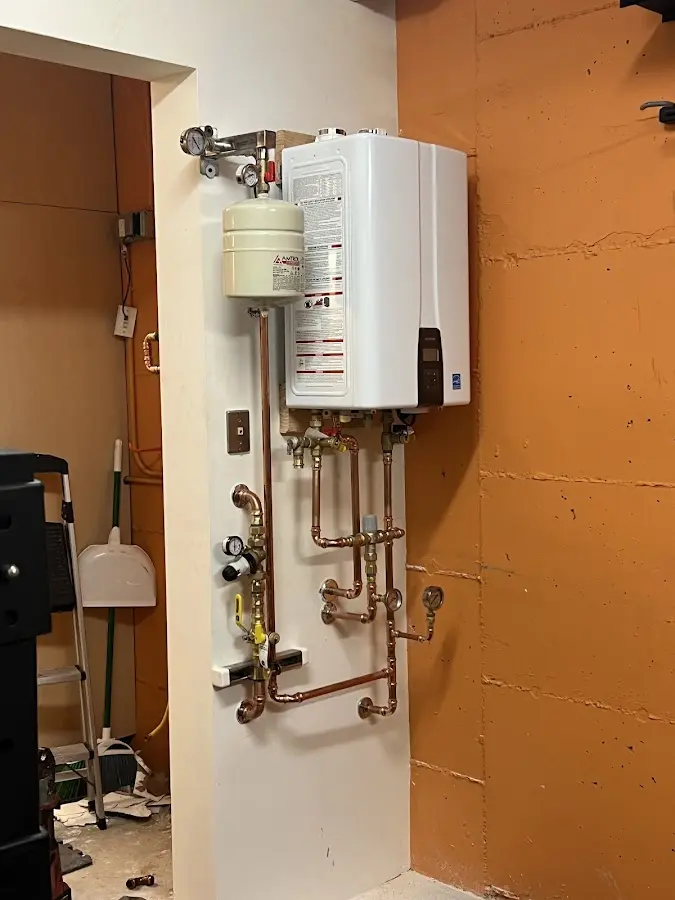 Plumbing technician inspecting water heater connections in Gresham Park
